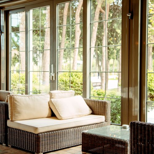 outdoor sofa with beige cushions and coffee table in front of the restaurant window